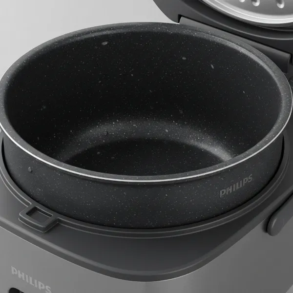A close-up view of the durable Bakuhanseki inner pot of a Philips Viva Collection rice cooker, showcasing its non-stick surface and mineral composition.
